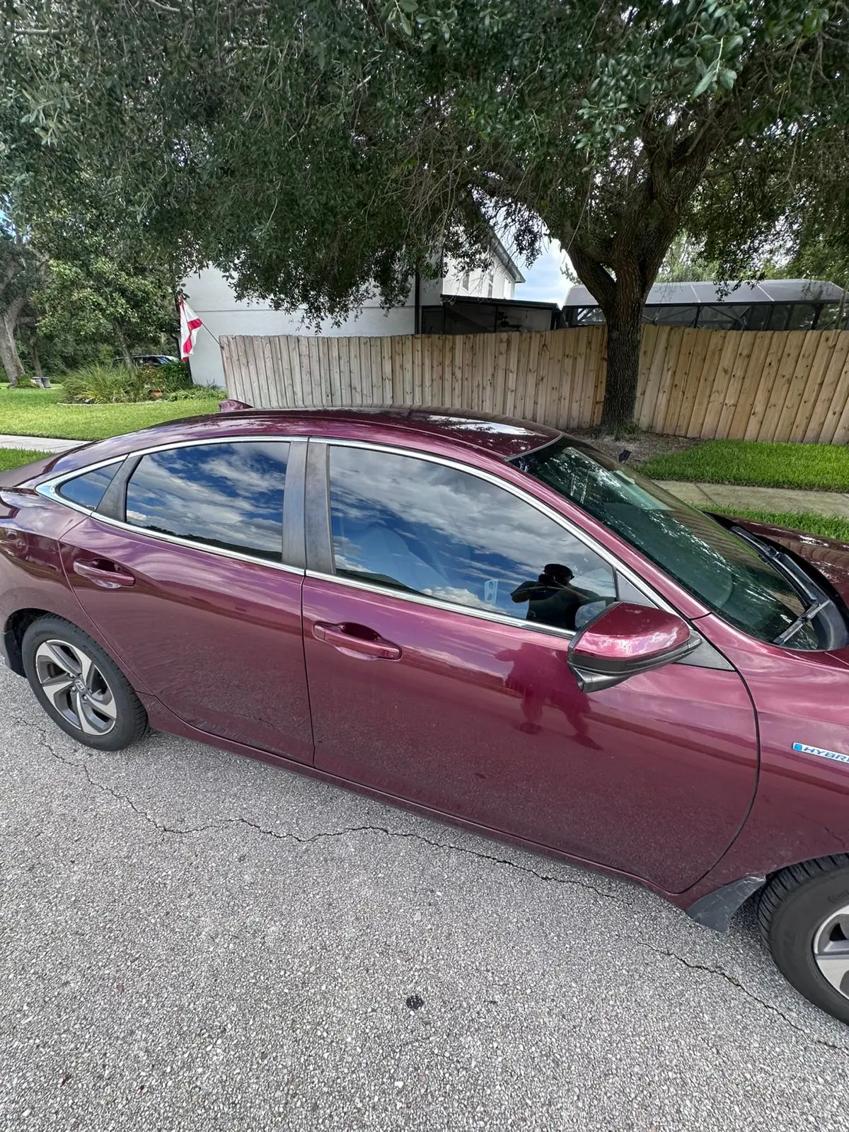 Burgundy Honda Accord with professional window tinting in residential setting