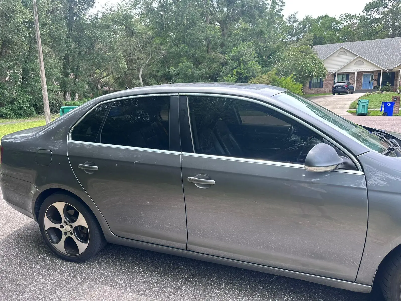 Gray sedan with professional window tinting in driveway