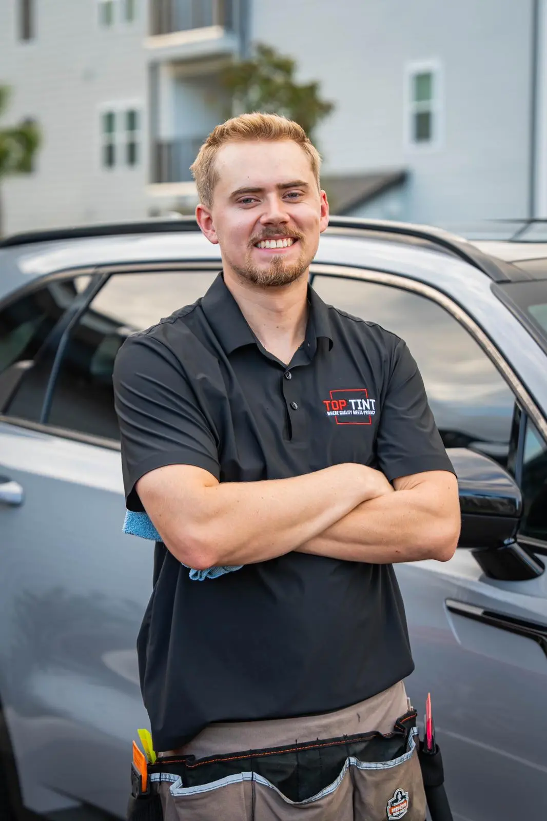 Matthew, Founder of Top Tint, standing confidently next to a vehicle